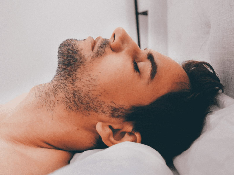 A man laying down on a pillow