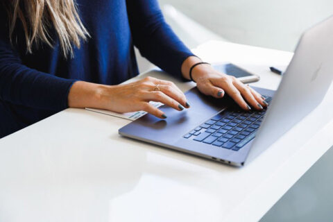 A woman typing on a laptop