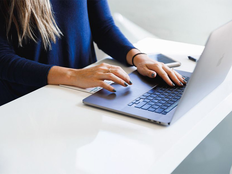 A woman typing on a laptop